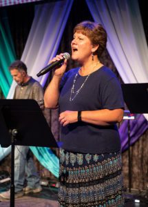 A worship singer singing during a service.