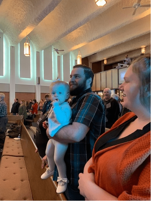 A father holding his child during a service.